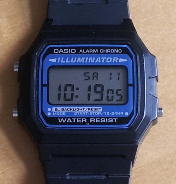 Front view of a black Casio F-105 family watch with blue Illuminator panel